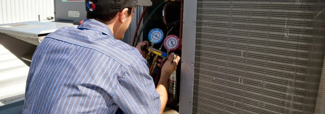 HVAC technician servicing a condenser unit in Broadview Heights